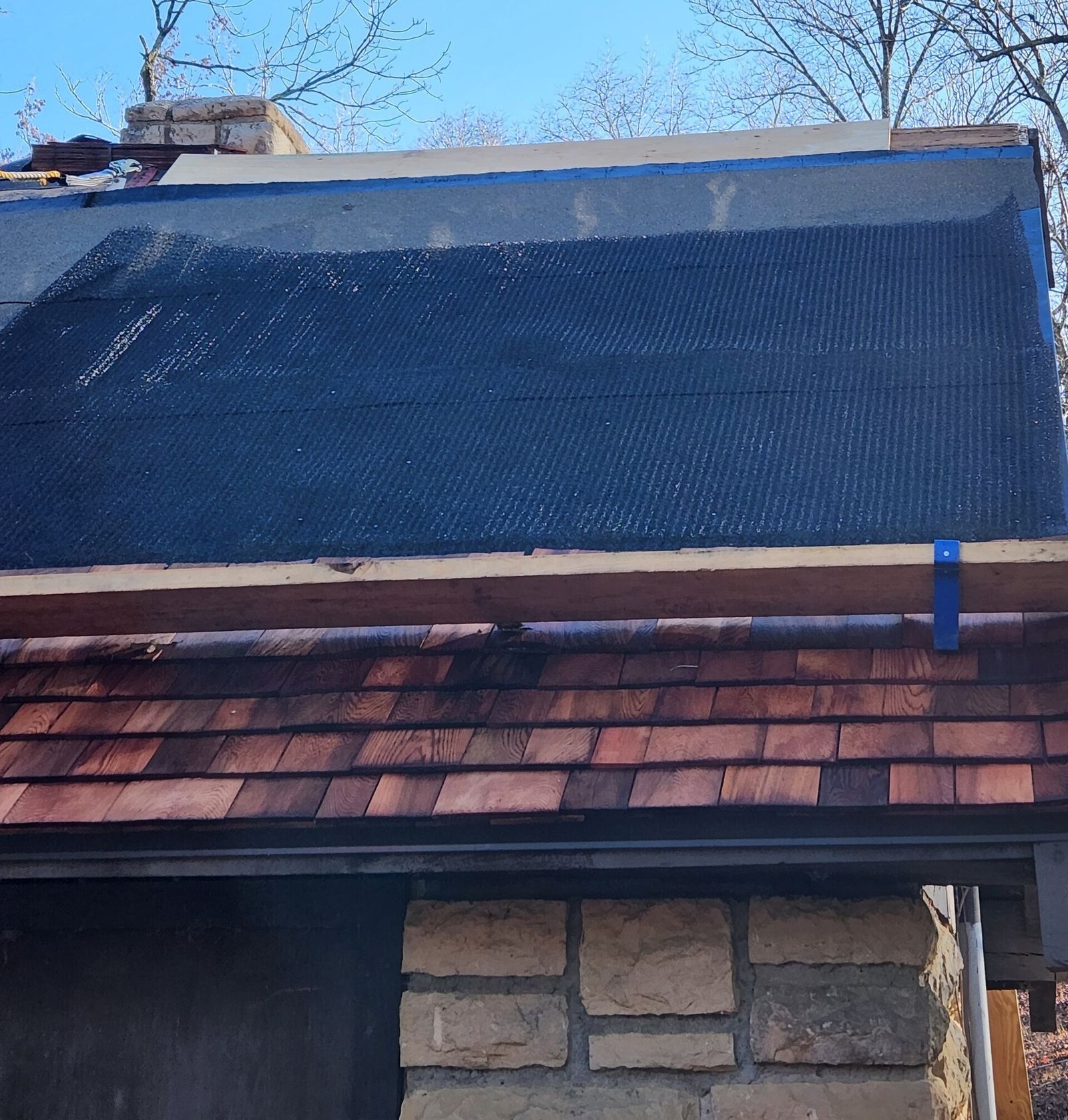 Ice and water shield rolled over a roof deck above a course of new shingles